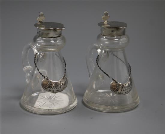 A pair of George V silver mounted glass spirit jugs and silver wine labels, John Grinsell & Sons, Birmingham, 1922/3, 10.2cm.